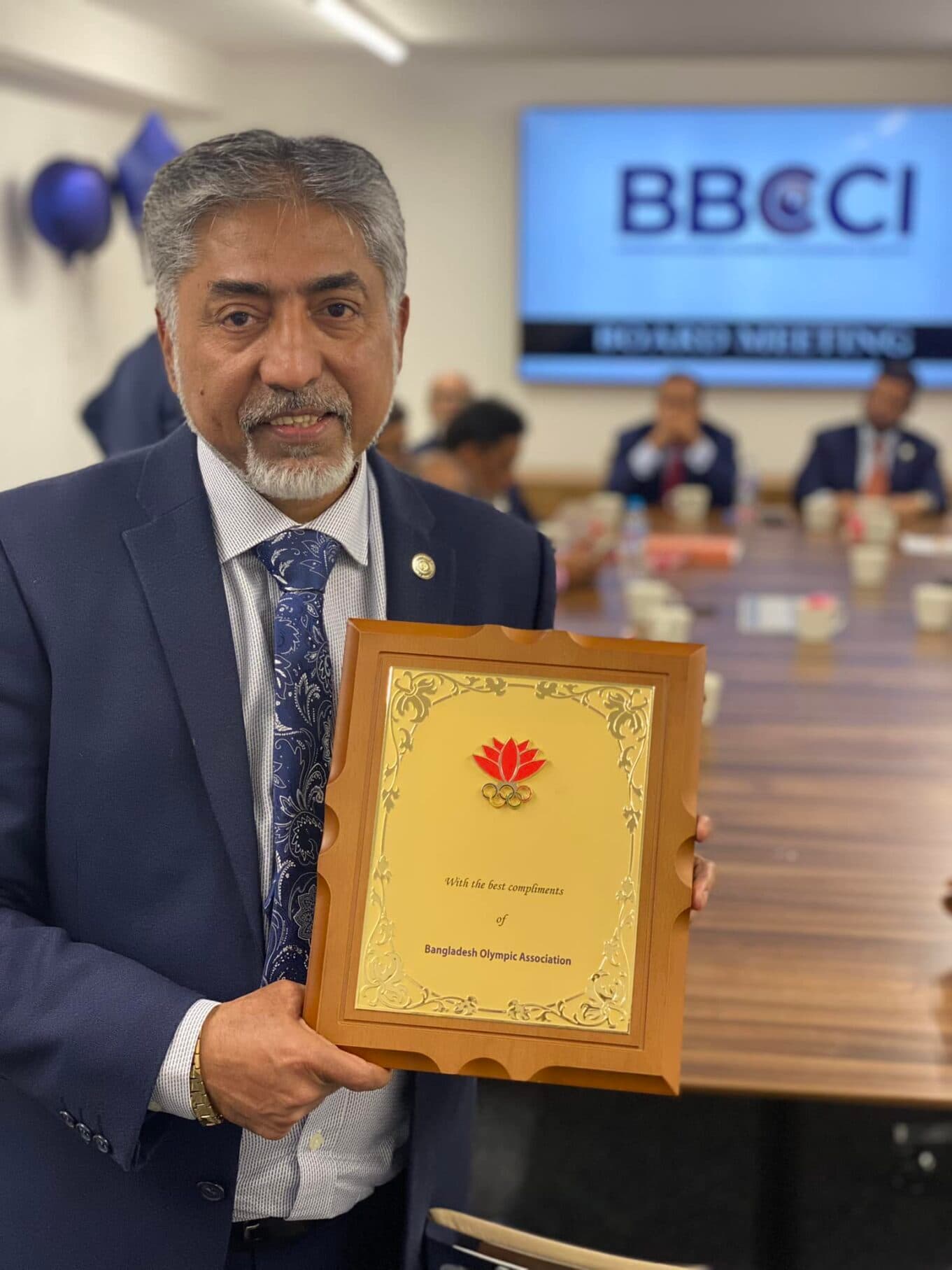 Holding a plaque at a BBCCI event